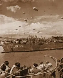 LST 502 beached on Omaha, June 1944. No less than 13 barrage balloons protect the immediate area. Note the LST's open door at left, with a crewman on the ramp. When the tide goes out, the LST will be high and dry and can begin unloading.