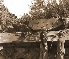 An M10 tank destroyed knocked out in the Villers-Bocage area, being examined by a junior officer from an Army (Heer) tank unit.