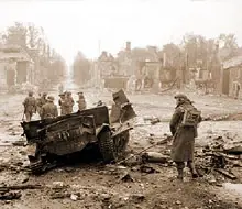 The remains of a universal carrier blown up by a mine in Tilly-sur-Seulles, 19 June 1944. Note the massive destruction at the back.